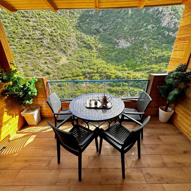 a patio with a table and chairs on a balcony at Akchour waterfalls in Akchour