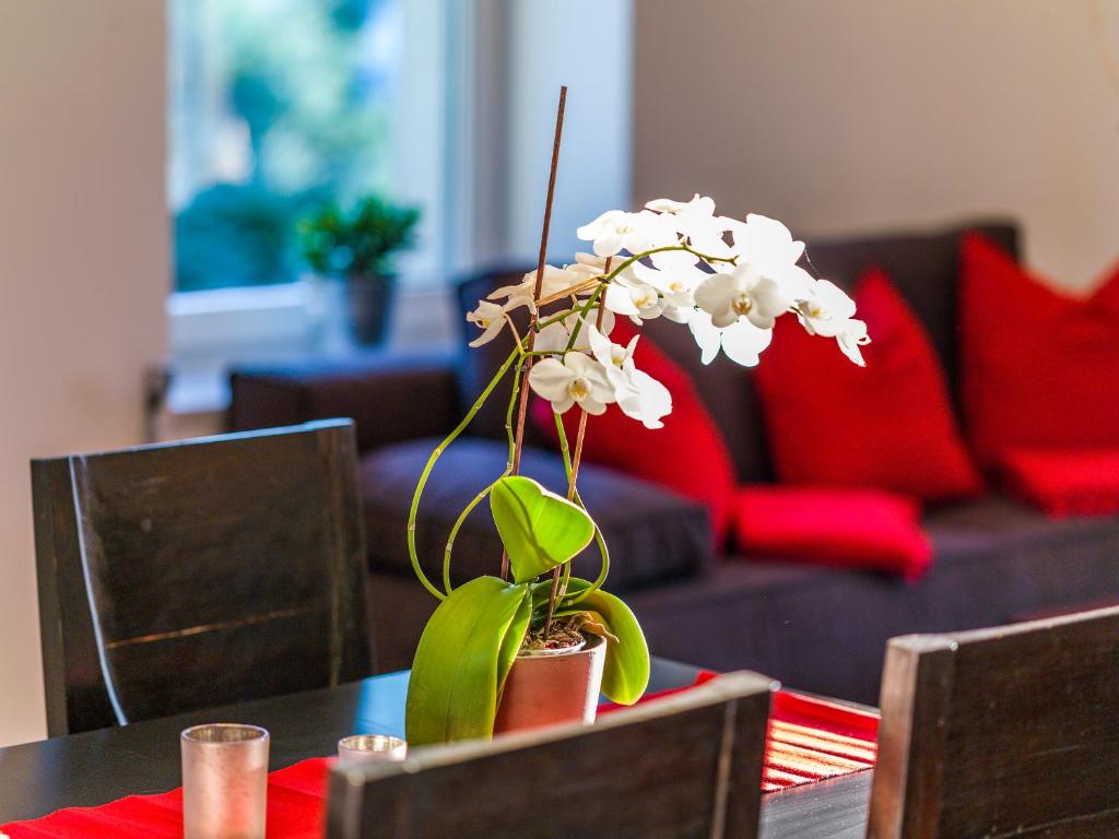 a table with a vase with white flowers on it at Apartment Zittera - Adults only in Innsbruck
