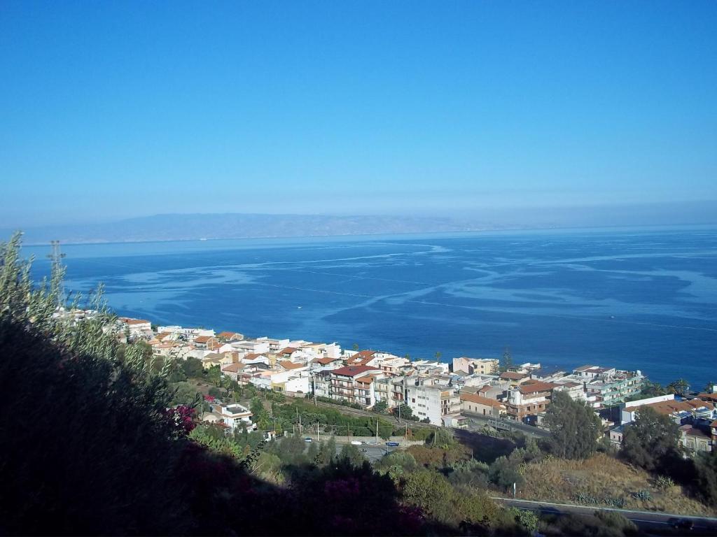 uma cidade numa colina junto à água em La Suite em SantʼAlessio Siculo