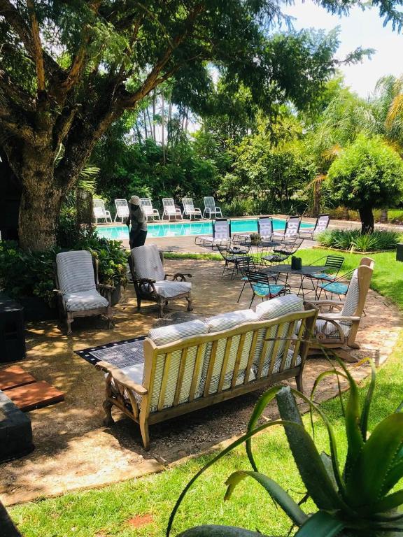 a bench and chairs next to a swimming pool at SPAat343 in Roodeplaat