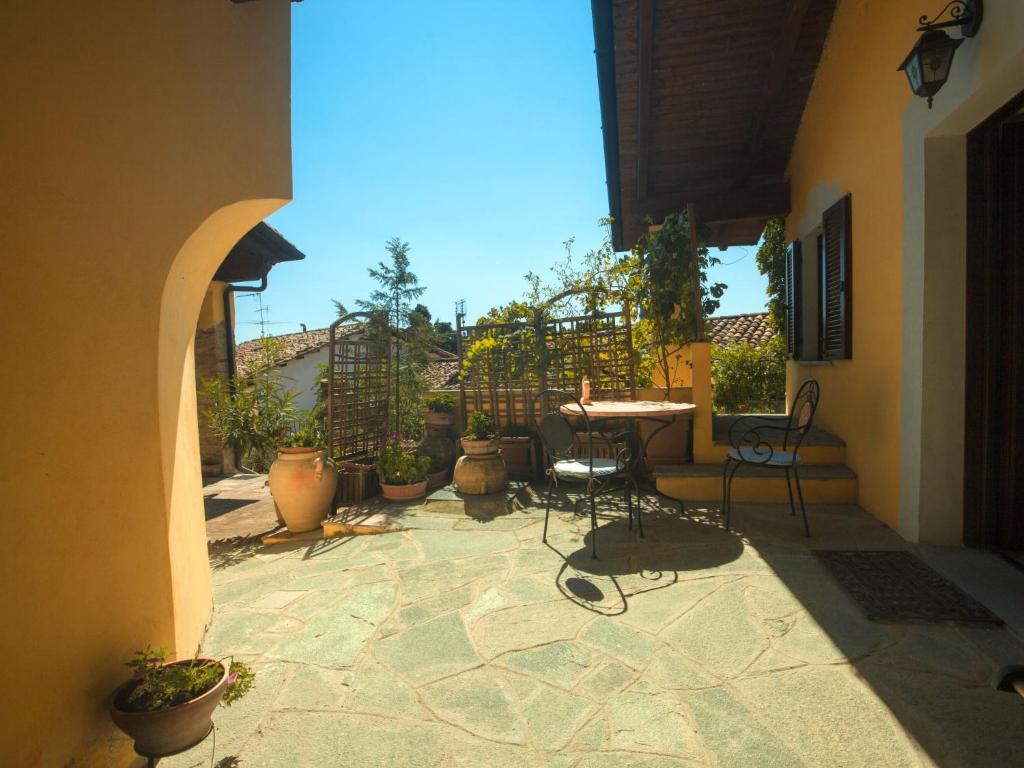 a patio with a table and chairs and potted plants at Apartment Girasoli by Interhome in Brusasco