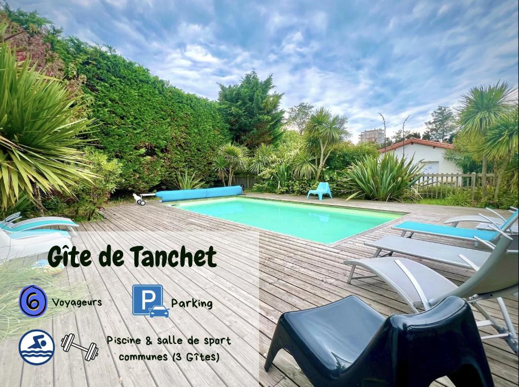 a villa with a swimming pool with chairs and trees at Maison Aquitaine "Tanchet" in Les Sables-d'Olonne