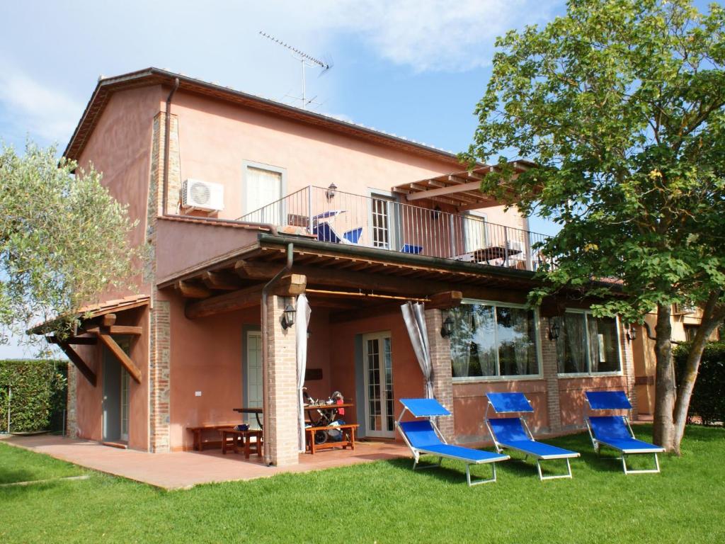 a house with blue chairs in the yard at Apartment Wohnung Leccio by Interhome in Castagneto Carducci