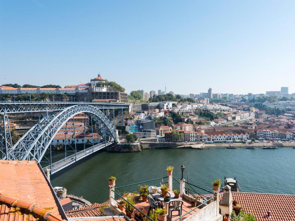 a bridge over a river with a train on it at Arco Apartments in Porto