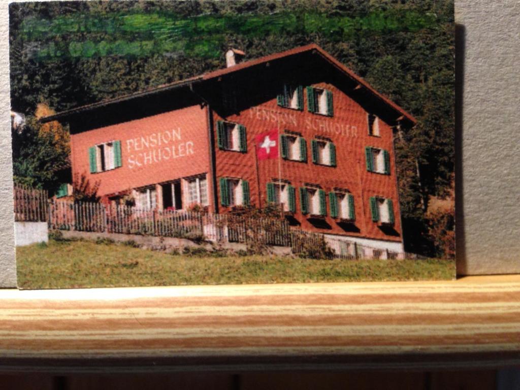 a picture of a red building with a house at Casa Schuoler in Disentis