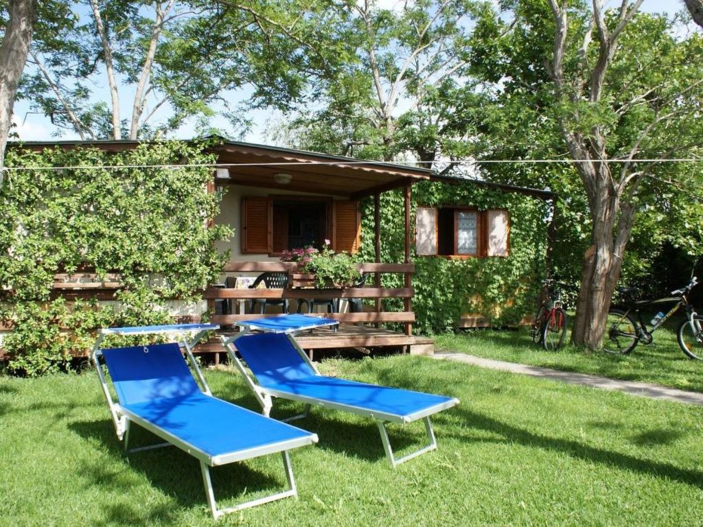 a couple of chairs and a table in the grass at Apartment Haus Jasmin by Interhome in Castagneto Carducci