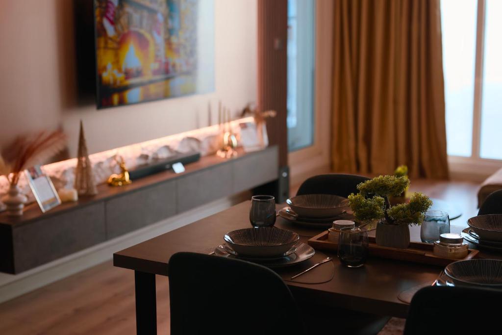 a dining room table with plates and dishes on it at Stellarlux Apartment, 35th floor in Skopje