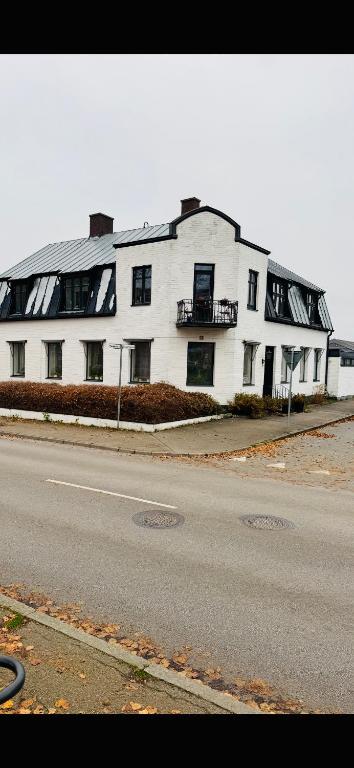 a large white building on the side of a street at Asken 8 in Klippan