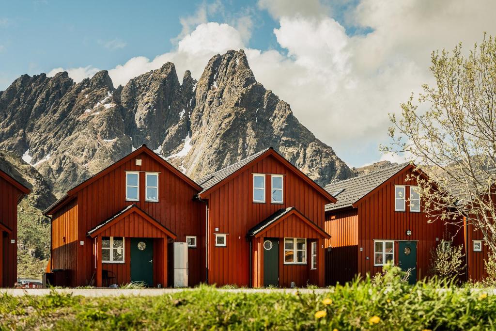 a row of red houses in front of a mountain at Skottinden Panorama Lofoten in Ballstad