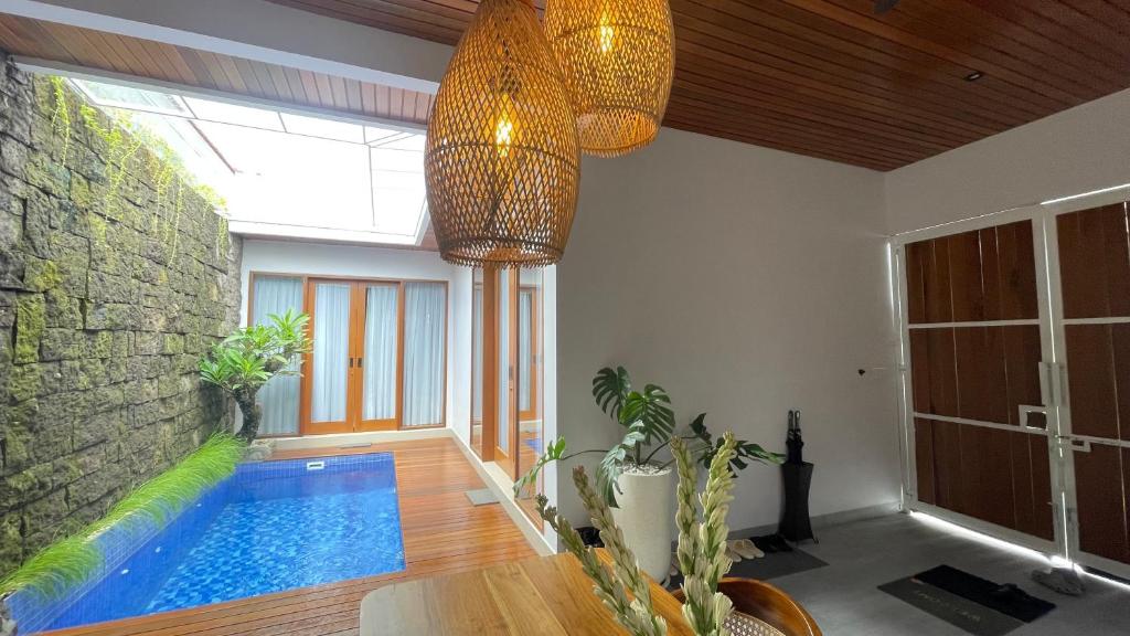 a living room with a swimming pool and a ceiling at Genta Villa Bali in Sanur