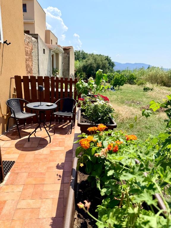 a patio with a table and chairs and flowers at Al vico1 in Campo Calabro