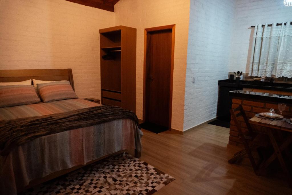 a bedroom with a bed and a piano at Chalé Recanto da Paciência in Camanducaia