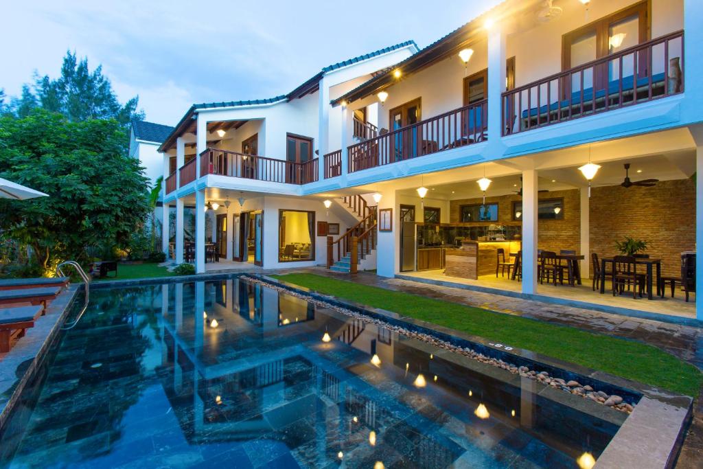uma casa com piscina em frente a uma casa em Vina Beach Pool Villas em Hoi An
