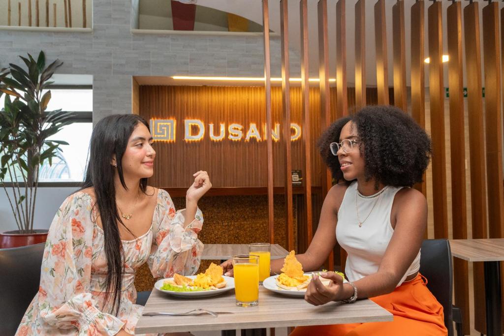 two women sitting at a table eating food at DUSANO BOUTIQUE HOTEL in Santa Marta