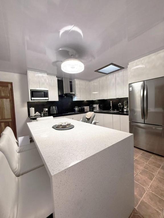 a kitchen with a white counter top in a room at Rohrmoser Eucalipto Luxe Residence in San José