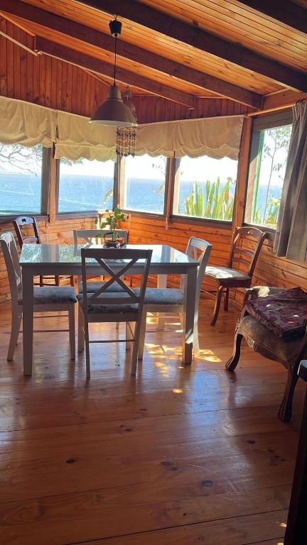 a dining room with a table and chairs and the ocean at Atardecer Inolvidable in Tomé