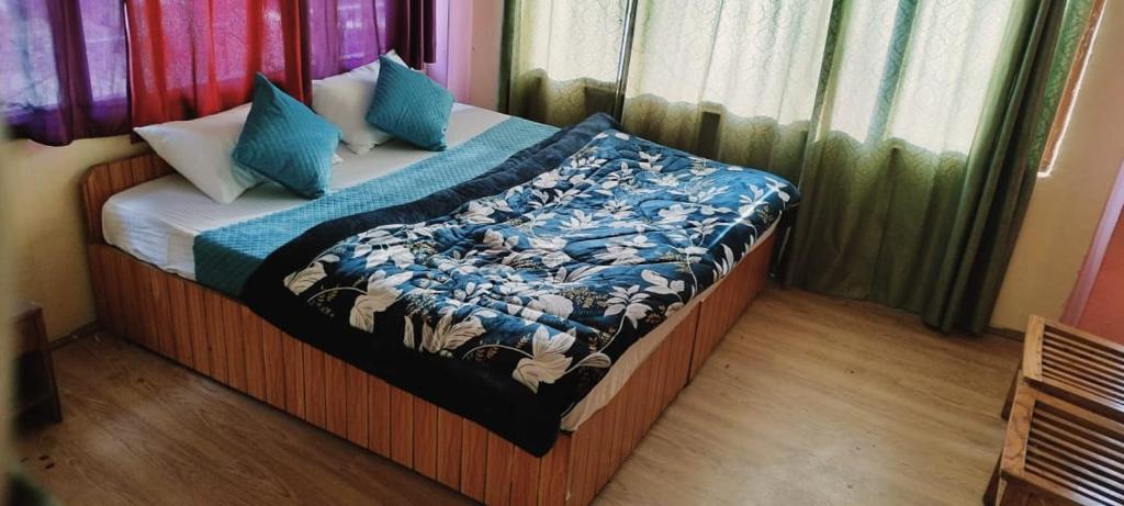 a bedroom with a bed with a blanket on it at Hotel Vamika in Manāli