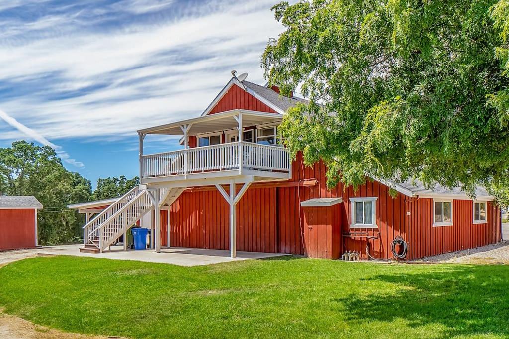 a red house with a balcony on the side of it at Red Barn Loft in Templeton