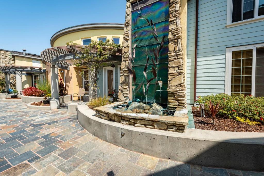 a house with a fountain in front of a building at Avila Beach Retreat in Avila Beach