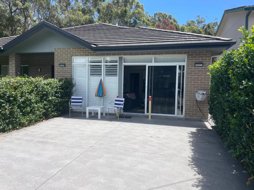 a house with two chairs and a patio at Serene Getaway in Callala Beach