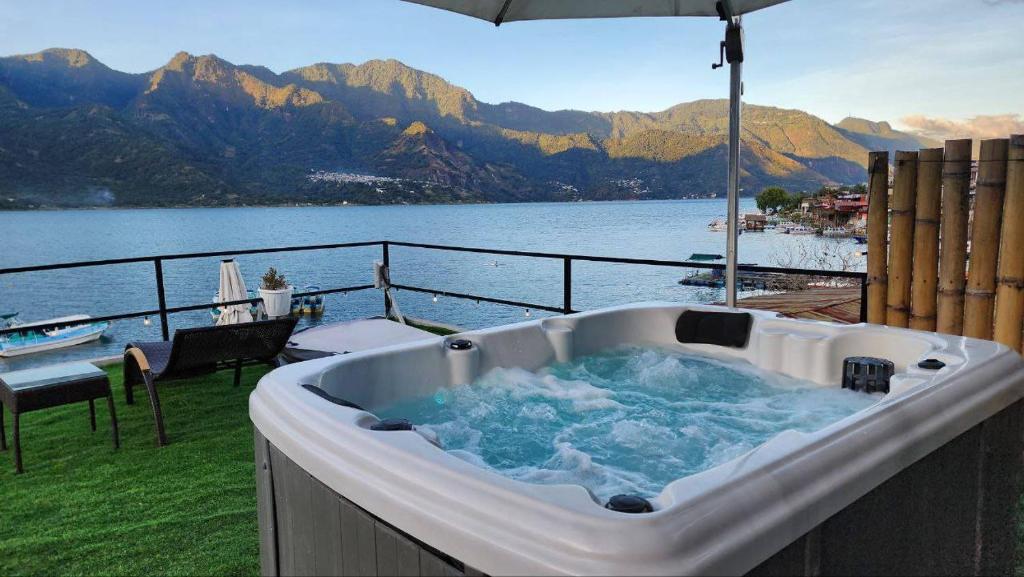 a bath tub on a deck with a view of the water at VENICE by luxury Atitlan in San Pedro La Laguna