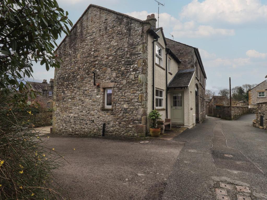 an old stone house in a village on a street at Tram Lane Cottage in Carnforth