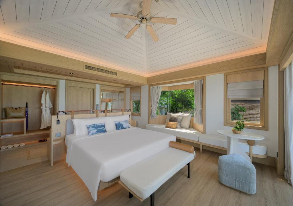 a bedroom with a white bed and a ceiling fan at Centara Villas Phi Phi Island in Phi Phi Islands