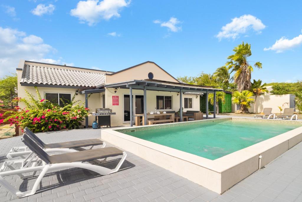a villa with a swimming pool and a house at Salinja Cerca 2-B in Palm-Eagle Beach