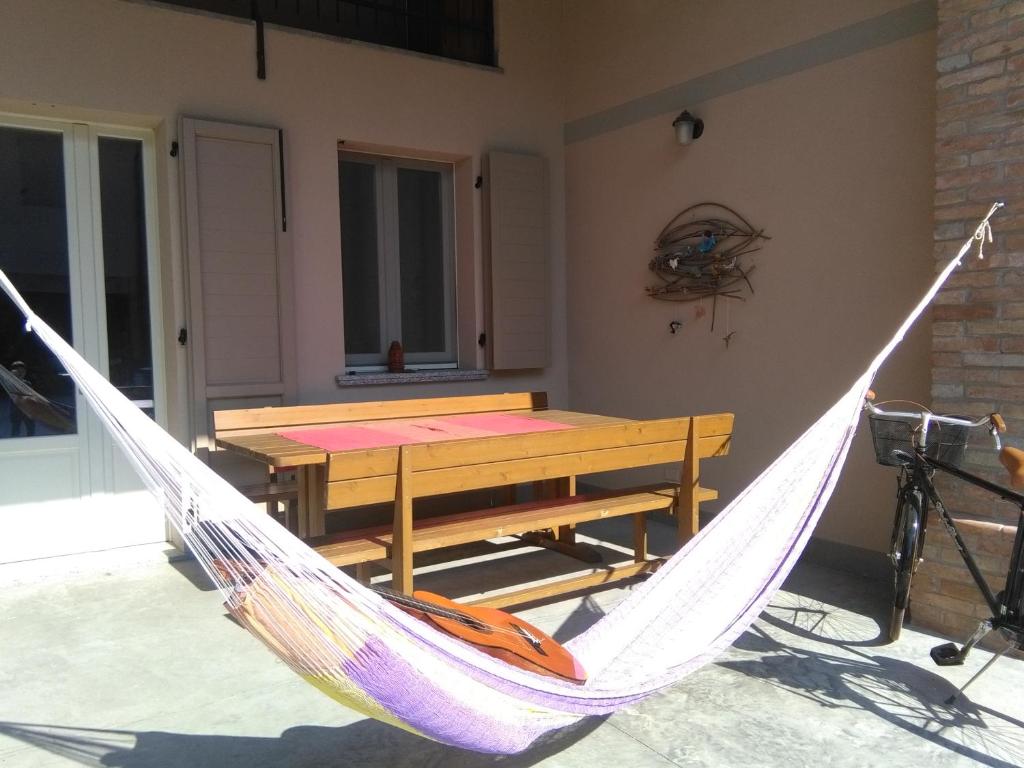 a hammock on a patio with a table and a bench at Up b&b in Offanengo