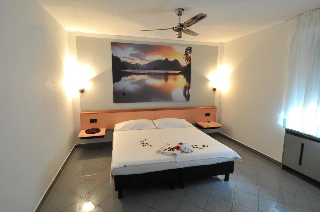 - une chambre avec un lit et une peinture murale dans l'établissement Hotel Bahnhof Haus, à Chiasso