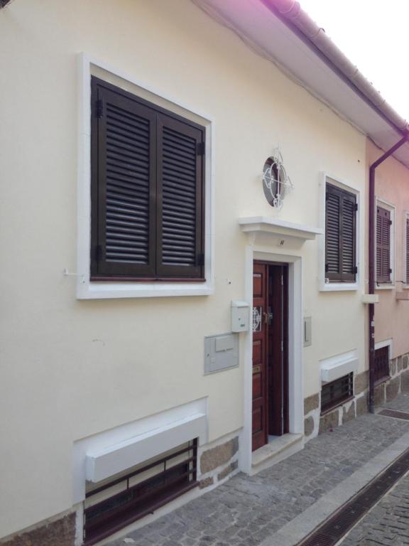una casa blanca con persianas negras y una puerta en T2P Félix House, en Vila Nova de Gaia
