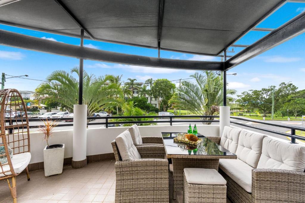 an outdoor patio with white furniture and a table at Luxurious Beachside Oasis with Ocean Views in Gold Coast