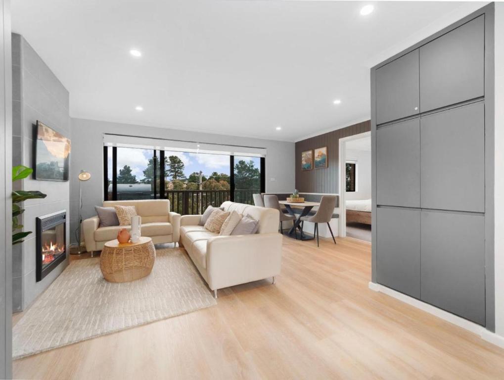 a living room with a couch and a fireplace at Lakeside Breeze in Jindabyne
