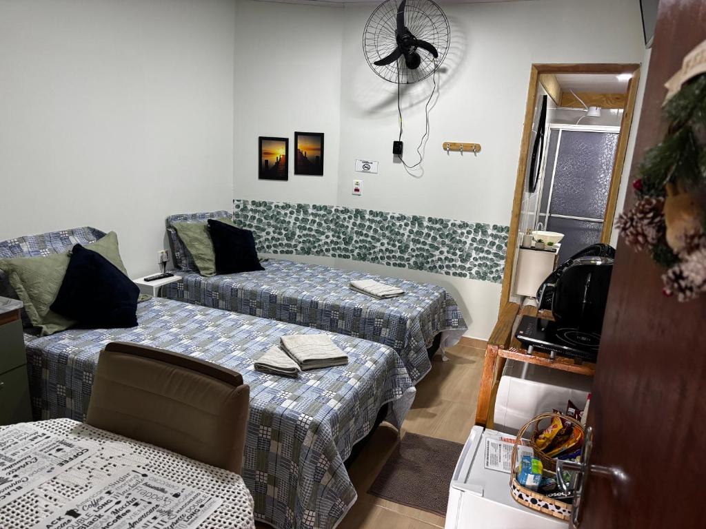 a room with two beds and a couch and a fan at Rancho do Viajante Quarto B2 in Castro