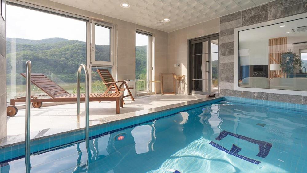 a swimming pool with a view of a house at Chuncheon The Van Pool Villa in Chuncheon