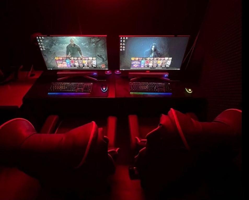 two computer monitors on a desk in a dark room at Dalbit Sori Hotel Jeonju in Jeonju