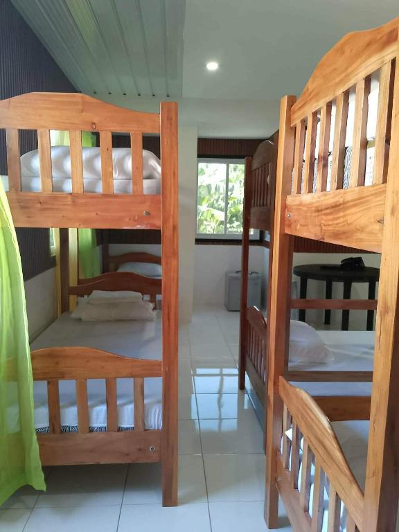 a room with three bunk beds in a house at MJ's Guesthouse in Tubod