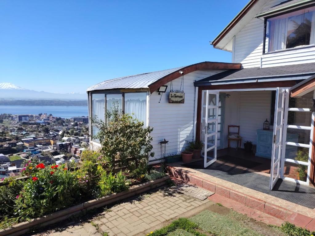 a white house with a view of the city at Vista volcanes house in Puerto Varas