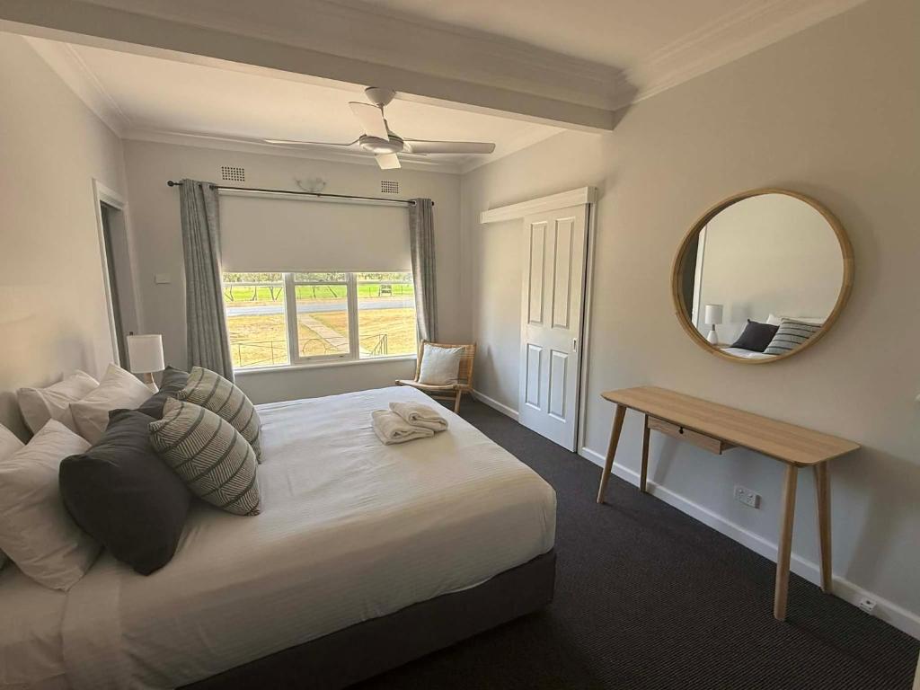 a bedroom with a bed with a mirror and a table at Units on Robertson in Mudgee