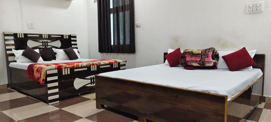 two beds in a room with sidx sidx sidx at Dev Guest House in Aklera