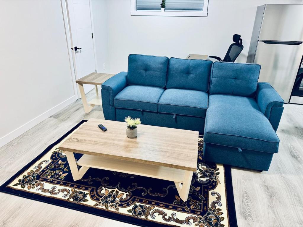 a blue couch and a coffee table in a living room at Maple Nest in Regina