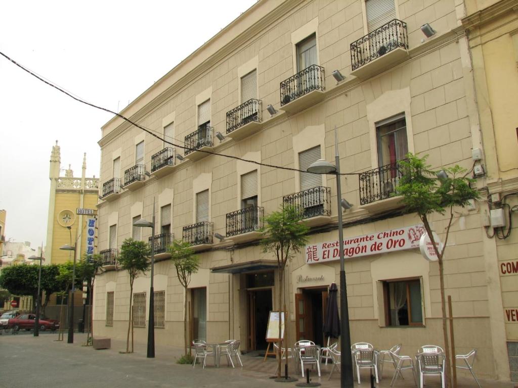 ein Gebäude mit Tischen und Stühlen davor in der Unterkunft Hotel Nacional Melilla in Melilla