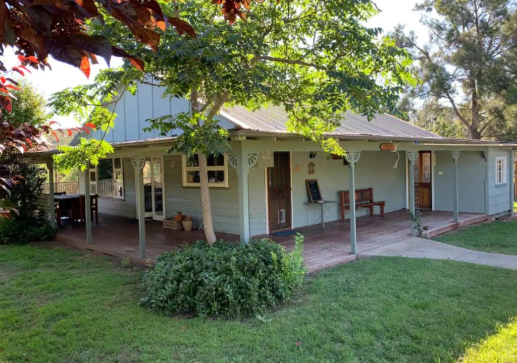 a white house with a porch and a yard at Winganna Farm in Peel