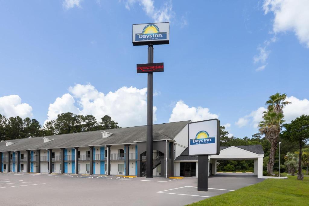 a building with a sign in a parking lot at Days Inn by Wyndham Hardeeville Near Hilton Head in Hardeeville