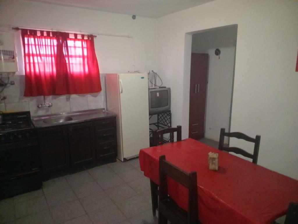 a kitchen with a red table and a refrigerator at Cabañas Sucot in Tanti