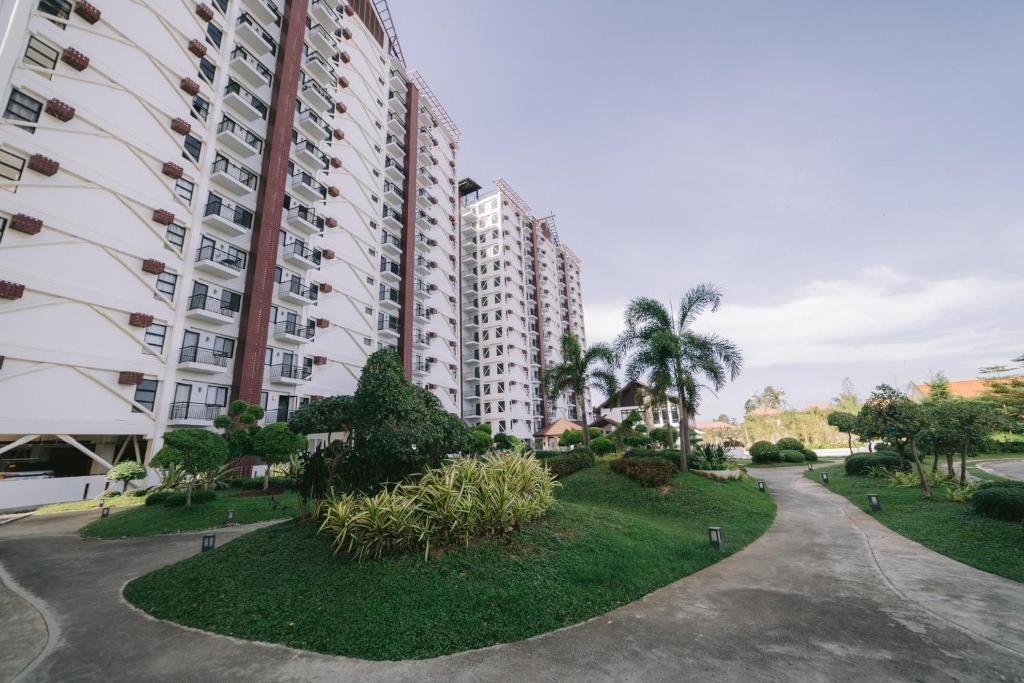 a large apartment building with a park in front of it at Instaworthy 1BR unit at Royal Oceancrest Mactan in Mactan Island