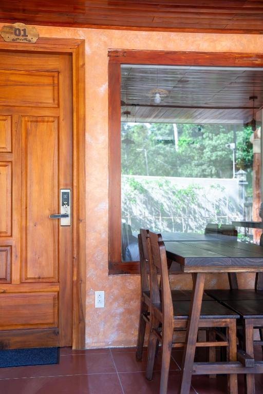 a dining room with a table and a window at Mango Village in Phú Quốc
