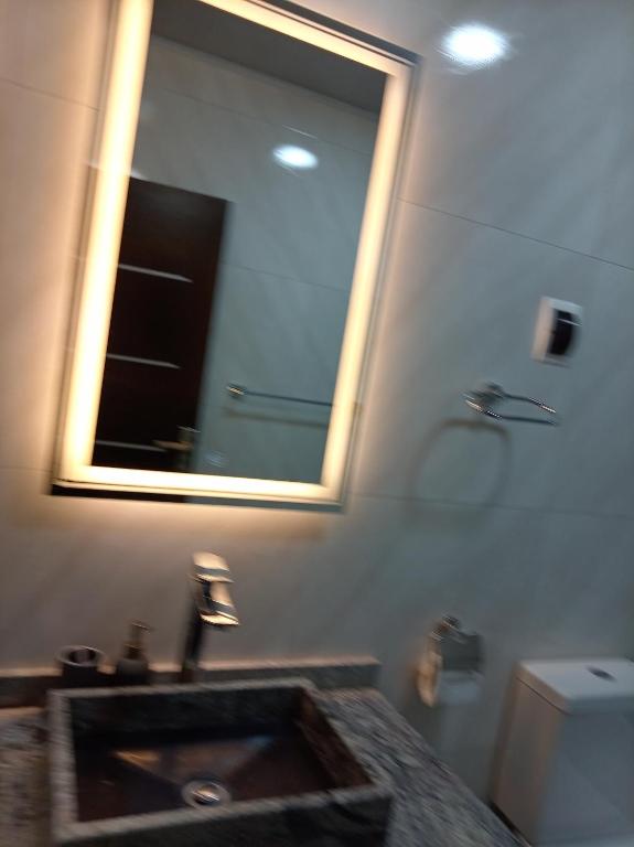 a bathroom with a sink and a mirror and a toilet at RoofTop in Kollpa