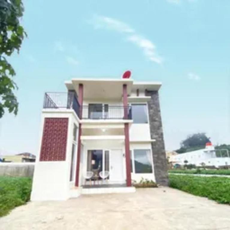 a large white house with a large driveway at Homestay Gavilla Dieng in Diyeng