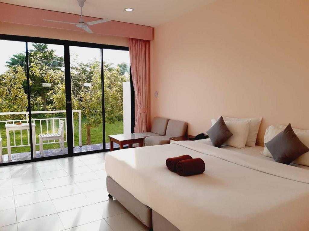 a bedroom with two beds and a large window at Xanadu Beach Resort in Ko Larn